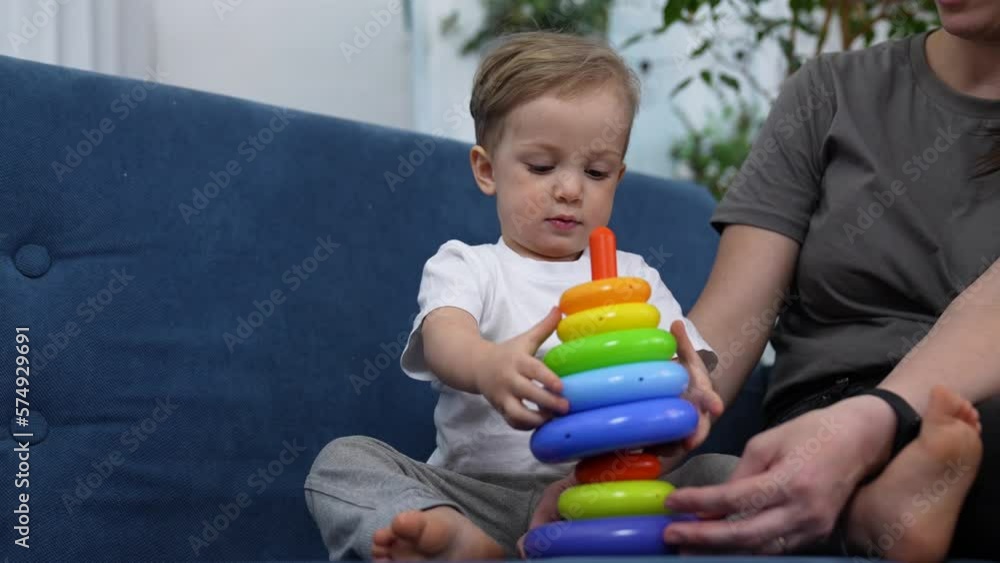 Happy cute family at home. Baby play with colored toys. Educational games for preschooler child. Mom helps child to play and have fun. Family happy education concept. Mom help in learning about world. Happy cute family at home. Baby play with colored toys. Educational games for preschooler child. Mom helps child to play and have fun. Family happy education concept. Mom help in learning about world.