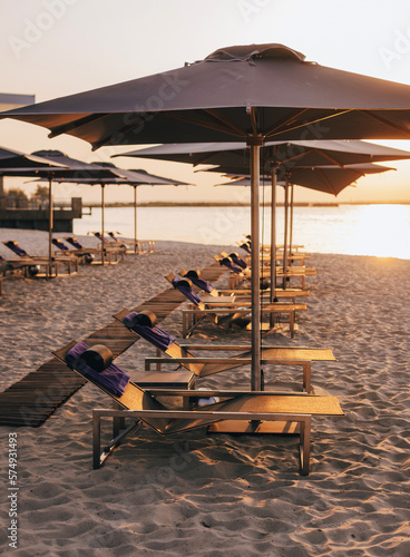 Rows of beach umbrellas and empty sunbeds on the beach  early morning. Travel and leisure concepts.