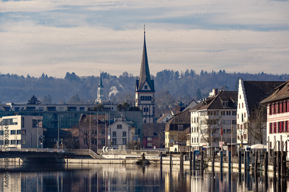 Scenic view of the old town of City of Schaffhausen with Minster church and Rhine River in the foreground on a sunny winter day. Photo taken February 16th, 2023, Schaffhausen, Switzerland.