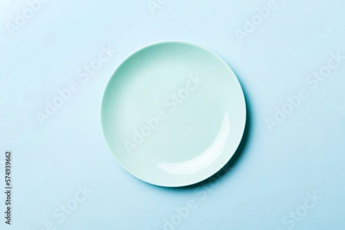 Top view of isolated of colored background empty round blue plate for food. Empty dish with space for your design
