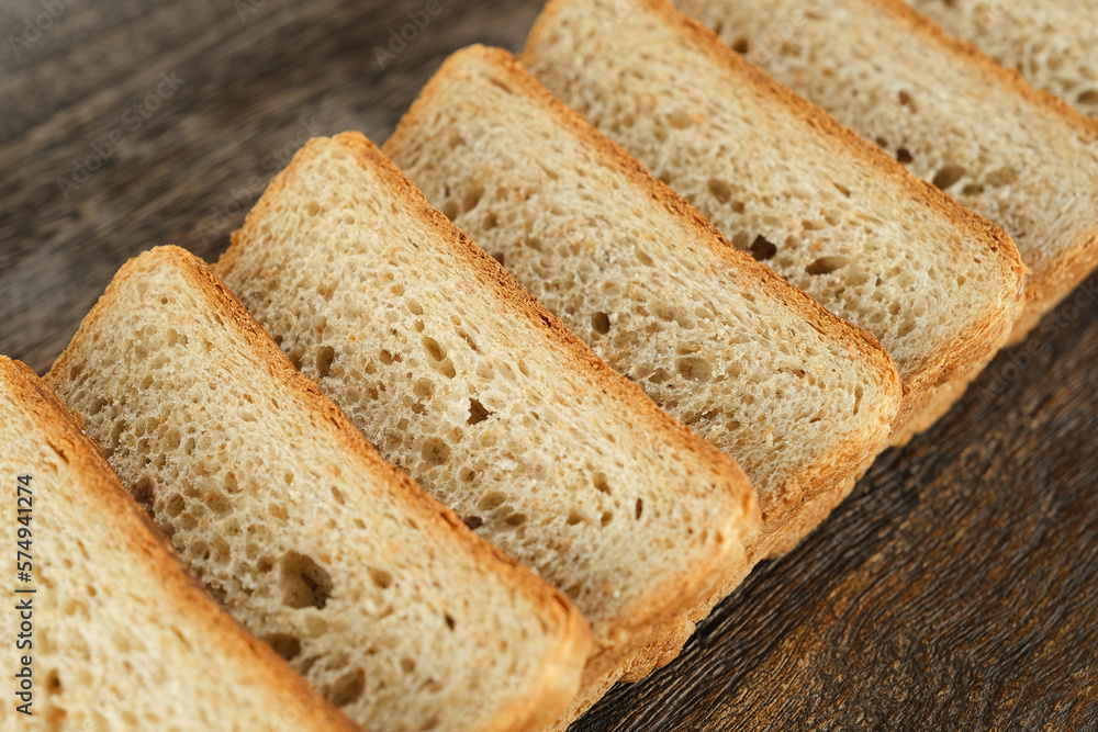 Slices of toast bread on wooden plate. Traditional bread for breakfast Slices of toast bread on wooden plate. Traditional bread for breakfast