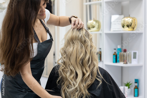 Woman getting curls from hairdressers