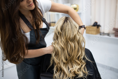 Woman getting curls from hairdressers