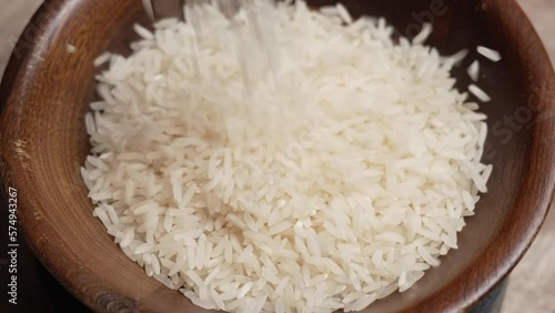 Dry Rice Poured in Wooden Bowl 