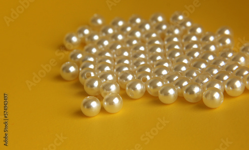 Beautiful white pearl bracelet jewelry beads for fashion or art and craft equipment. Object photo isolated on yellow background.