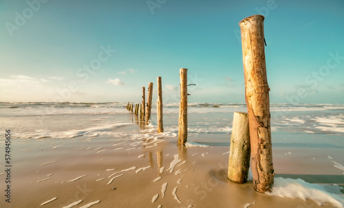 Wellenbrecher - Holzpfosten am Nordseestrand auf der dänischen Insel Römö - Langzeitbelichtung photo