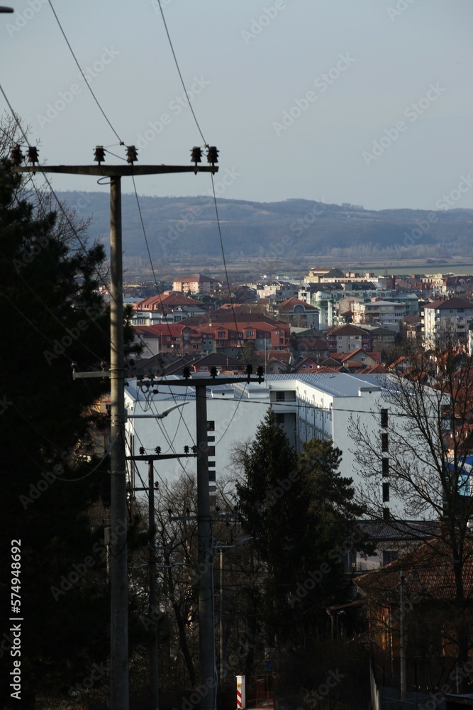 City visible from the hill, power line and poles on the left