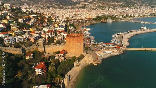 Flying copter over old sunny town Alanya to famous Fortress Tower in Antalya Province. Turkey. Ancient city is overwashed by Mediterranean sea. photo