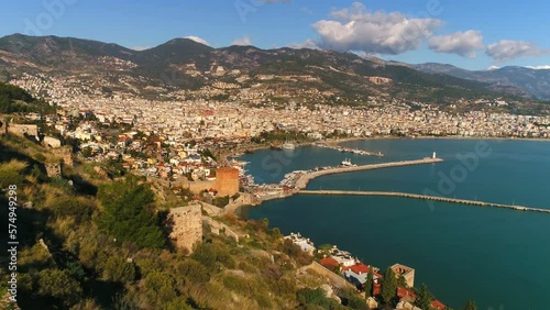 Panorama of beautiful sunny town Alanya on mountains overwashed by Mediterranean sea. Antalya Province, Turkey. Flying copter footage. photo