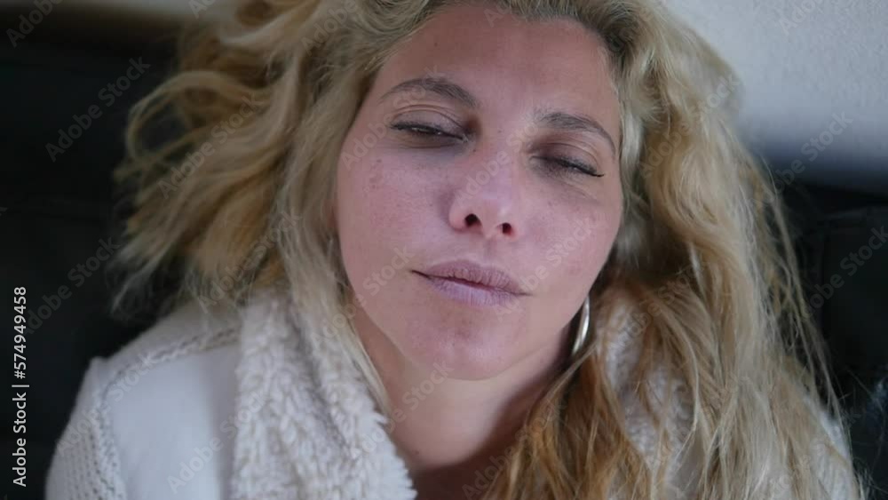 Close-up of a sick woman resting as she briefly opens her eyes. Close-up of a sick woman resting as she briefly opens her eyes.