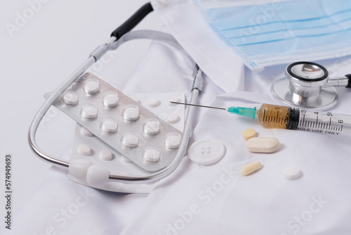 stethoscope,pills,syringe on a doctor's gown