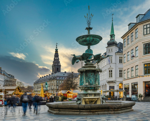 Long exposure shot of the Stork Fountain, Amagertorv in central Copenhagen on a busy evening, Denmark photo