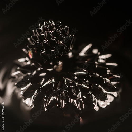 Dark ferrofluid crown with effect of magnetism in light rays photo