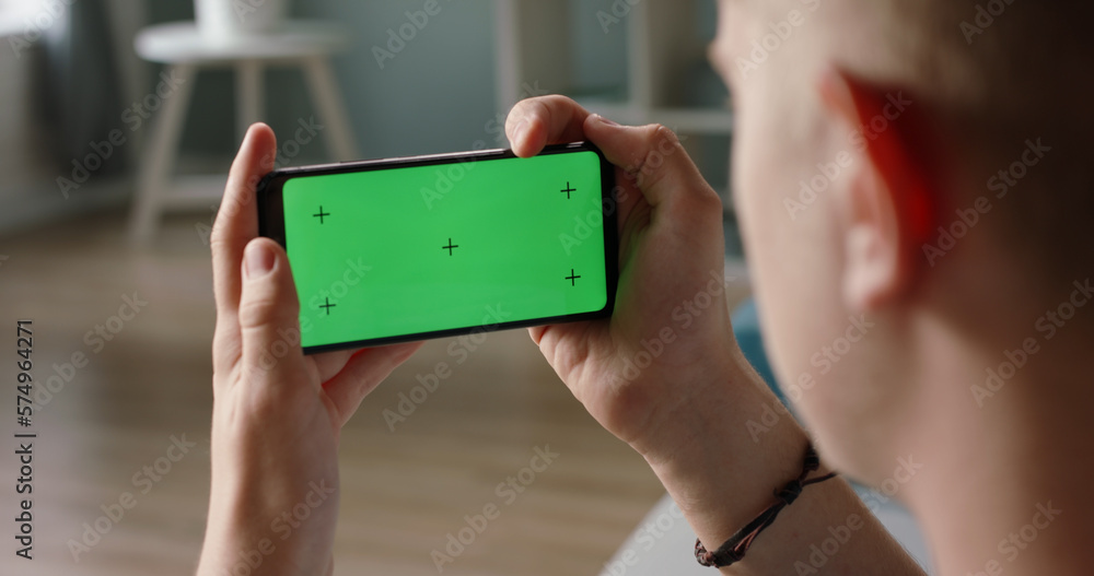 Man using a smart phone with mock up green screen, talking while having an online conference - online education, communications concept close up Man using a smart phone with mock up green screen, talking while having an online conference - online education, communications concept close up