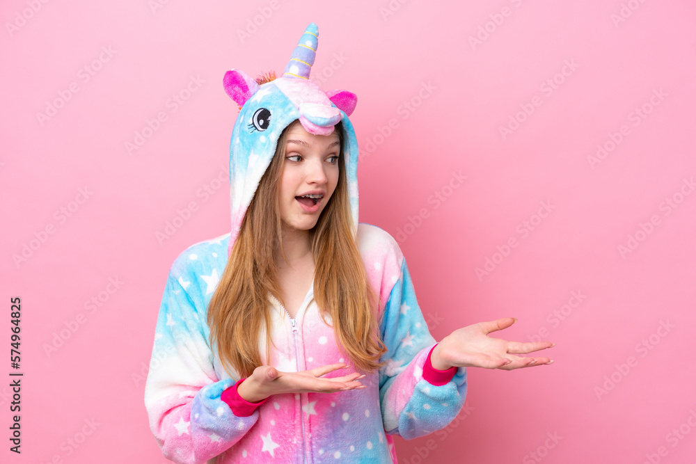 Teenager Russian girl with unicorn pajamas isolated on pink background with surprise facial expression
