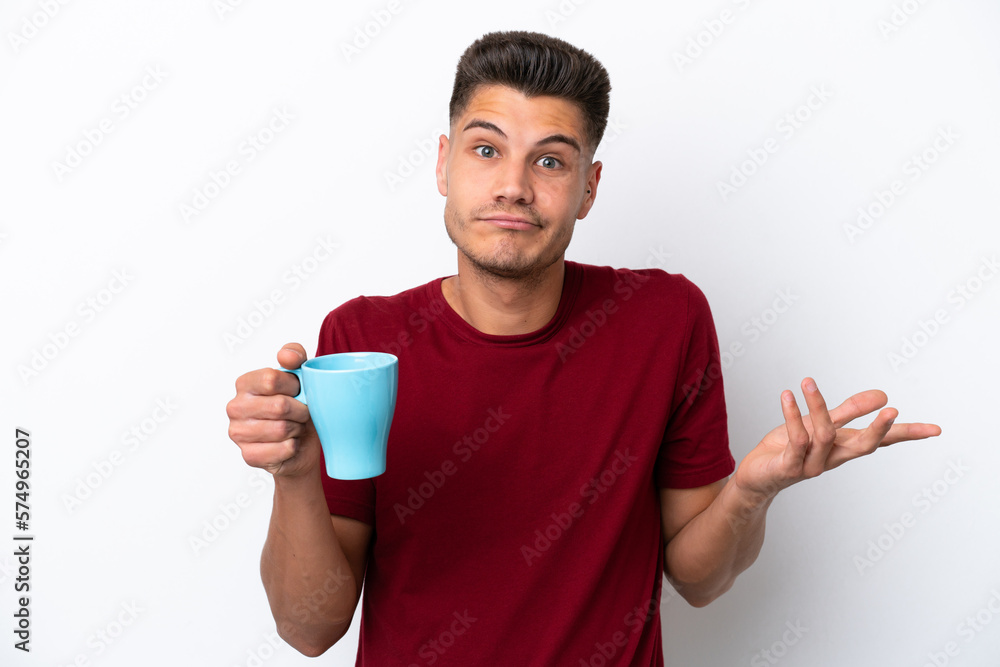 Young caucasian man holding cup of coffee isolated on white background making doubts gesture while lifting the shoulders Young caucasian man holding cup of coffee isolated on white background making doubts gesture while lifting the shoulders