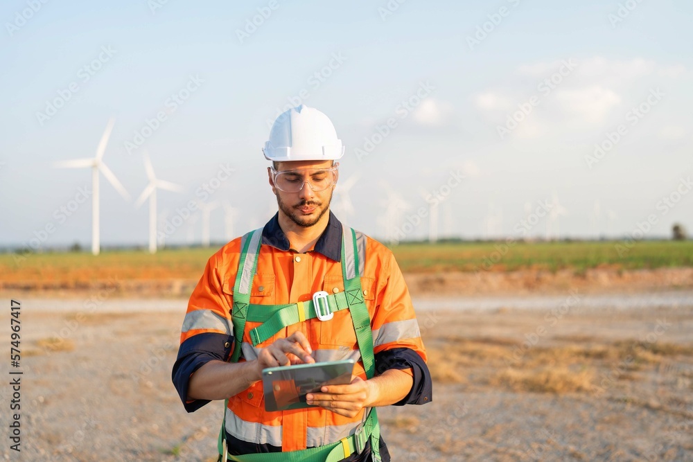 Wind turbine service engineer standing on ground planning for maintenance electricity generator Wind turbine service engineer standing on ground planning for maintenance electricity generator