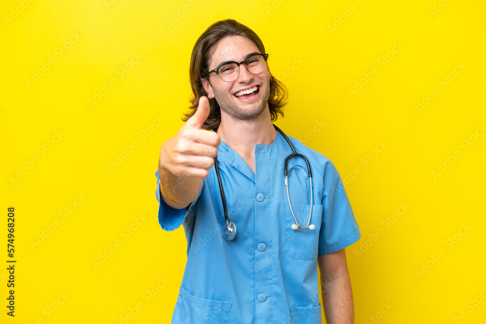 Young surgeon caucasian man isolated on yellow background with thumbs up because something good has happened