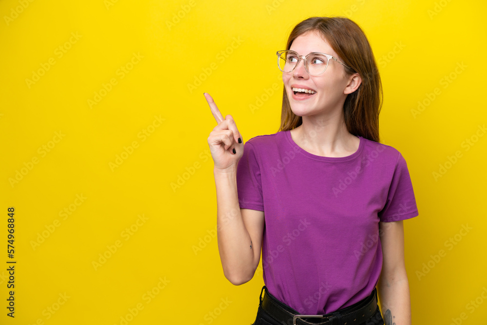 Young English woman isolated on yellow background intending to realizes the solution while lifting a finger up Young English woman isolated on yellow background intending to realizes the solution while lifting a finger up