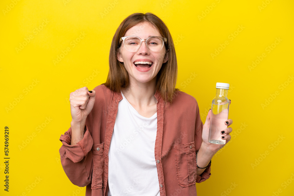 Young English woman with a bottle of water isolated on yellow background celebrating a victory in winner position Young English woman with a bottle of water isolated on yellow background celebrating a victory in winner position