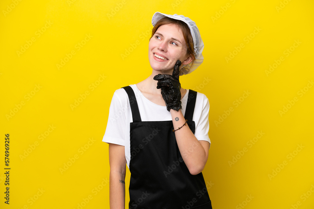 Young English fisherwoman isolated on yellow background thinking an idea while looking up