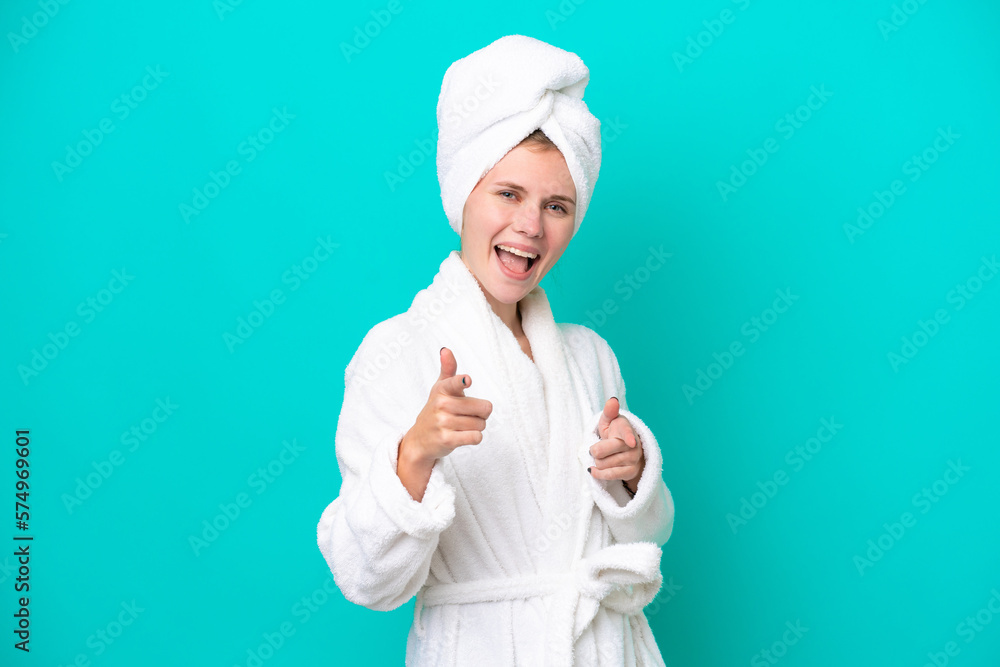 Young woman in a bathrobe isolated on blue background pointing to the front and smiling Young woman in a bathrobe isolated on blue background pointing to the front and smiling
