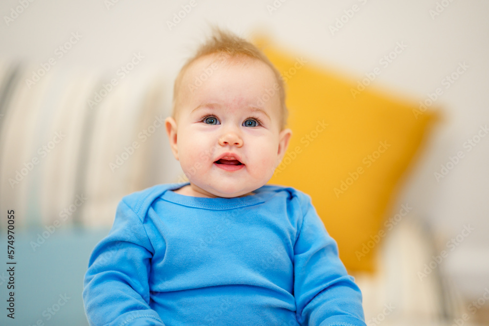 Portrait of charming Caucasian baby toddler with blue eyes in home in children room
