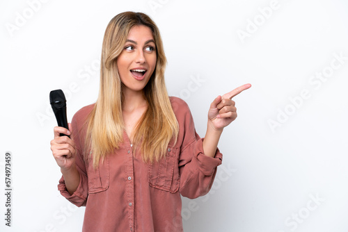 Singer Uruguayan woman picking up a microphone isolated on white background intending to realizes the solution while lifting a finger up