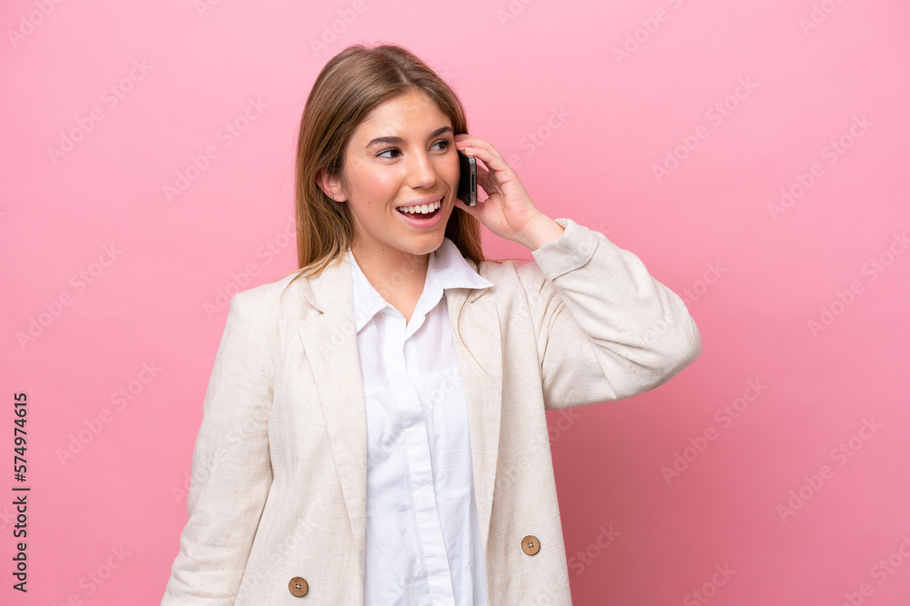 Young caucasian woman isolated on pink bakcground keeping a conversation with the mobile phone Young caucasian woman isolated on pink bakcground keeping a conversation with the mobile phone