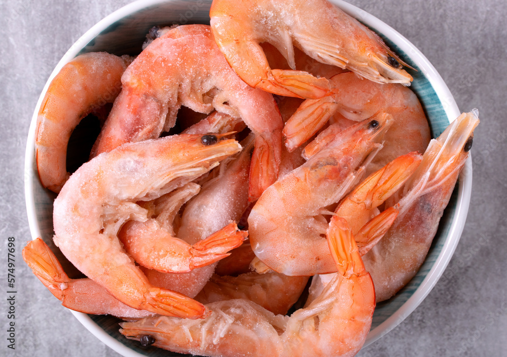 Shrimps in bowl. Frozen boiled seafood product. Top view. Close-up Shrimps in bowl. Frozen boiled seafood product. Top view. Close-up
