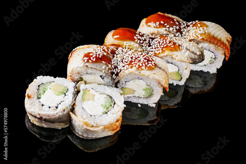 sushi roll with avocado cucumber cream cheese eel unagi on a black mirror background