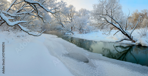 Winter frosty panoramic landscape with forest river and snow covered trees in calm december morning