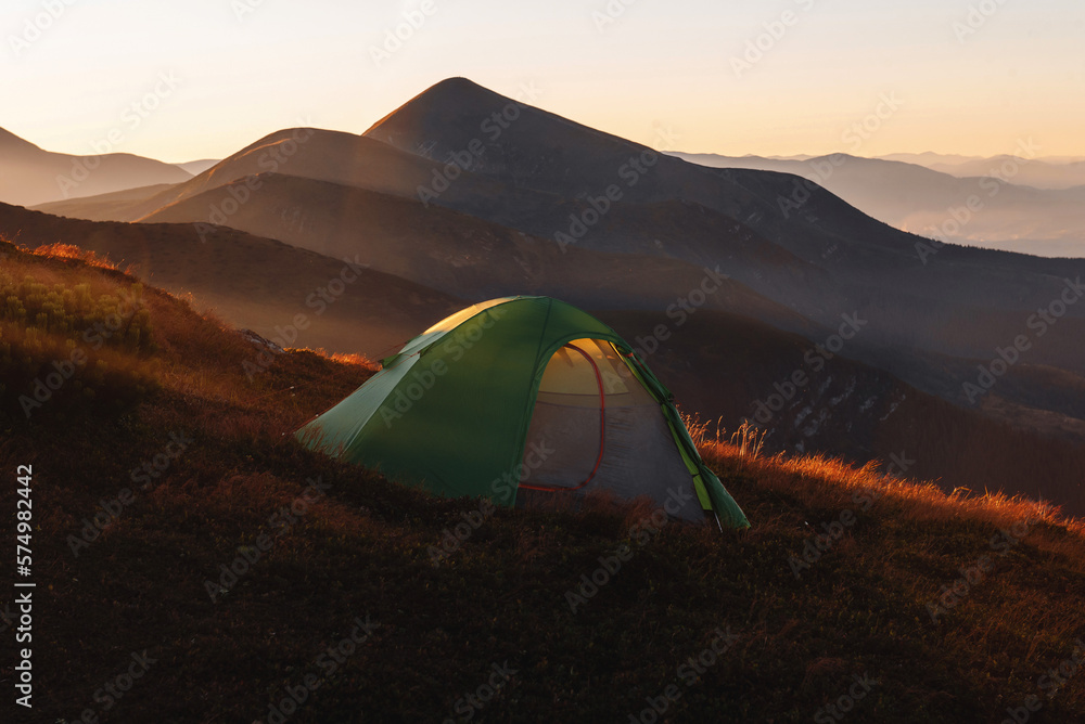 Green camping tent on top of mountain