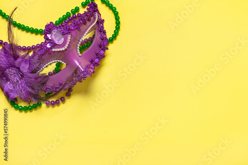 Mardi gras concept. Congratulation card with violet mask on yellow background Top view 2023 Mardi Gras Parade Schedule Mockup Copy space