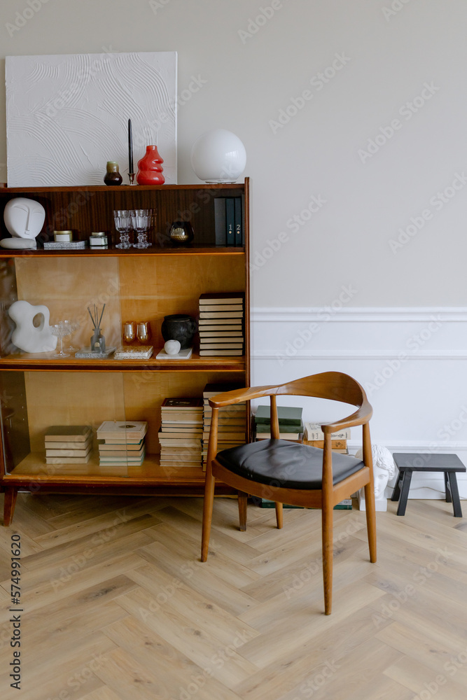 Classic interior in the room. Bookcase with books, armchair and table. Classic interior in the room. Bookcase with books, armchair and table.