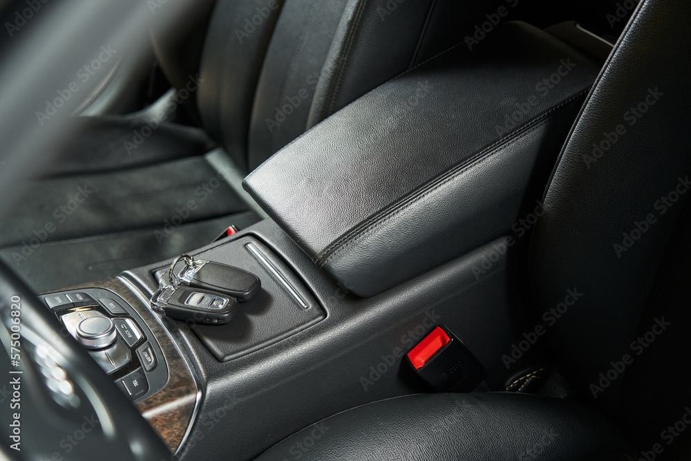 leather car armrest, keys lying on a hidden storage box leather car armrest, keys lying on a hidden storage box