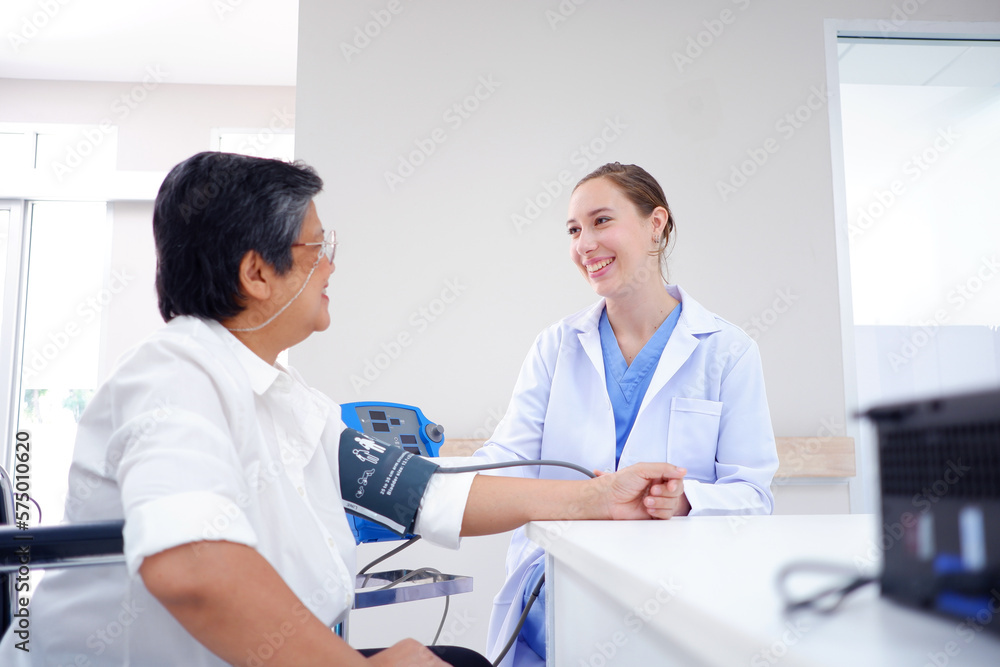 Fototapeta premium Female doctor measuring blood pressure, old woman patient, medical concept.