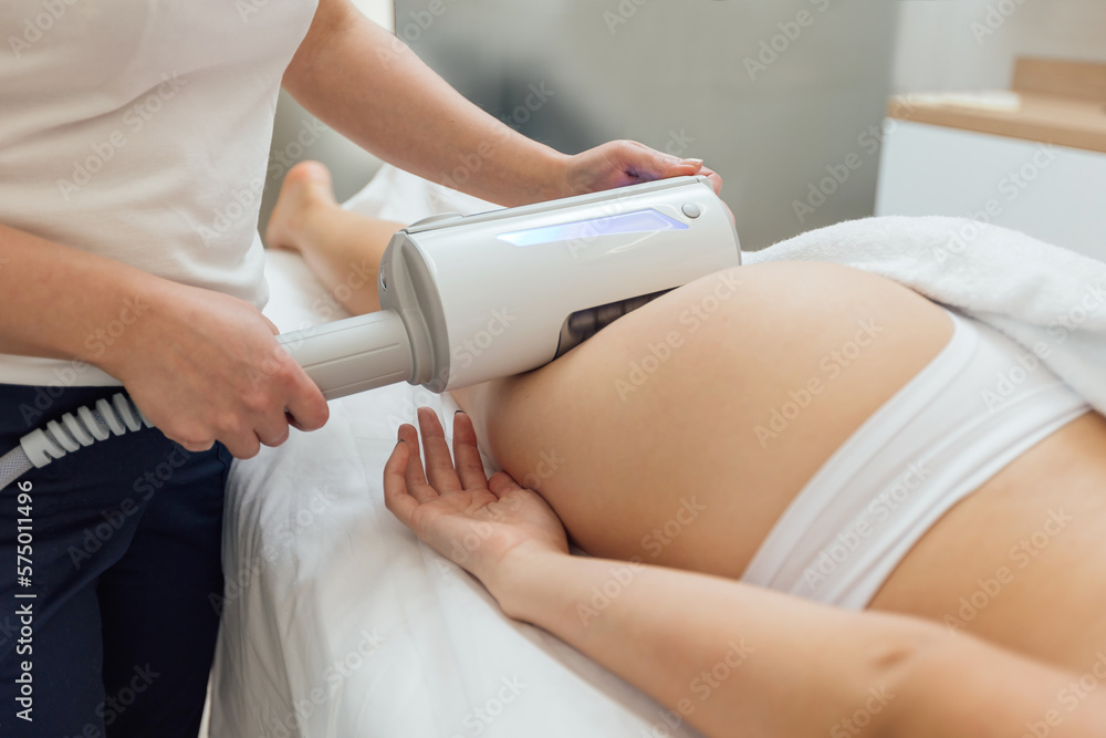 Fototapeta premium Cosmetologist uses device on a female's body