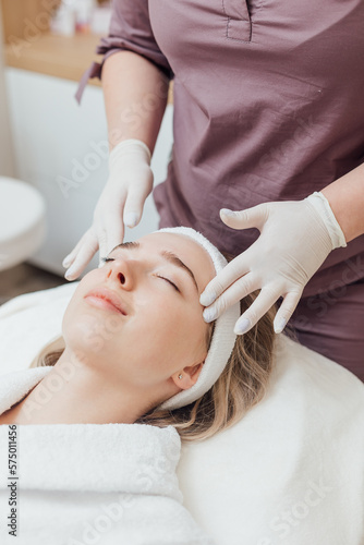 An expert cosmetologist performs an analysis of the patient's facial skin