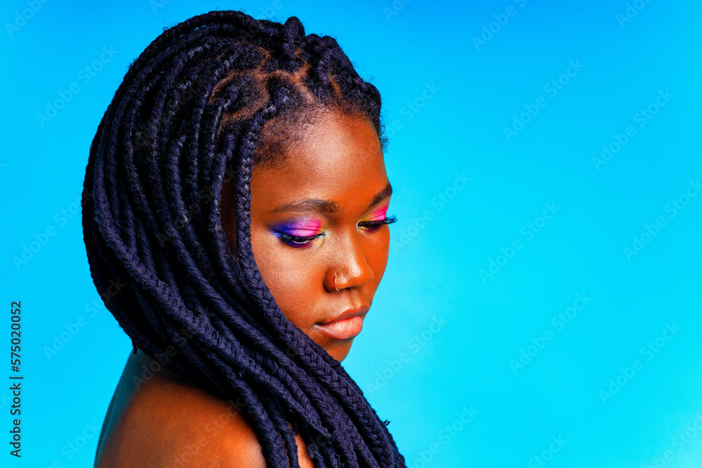 hispanic woman with nose piercing and colorful rainbow make up in blue studio background hispanic woman with nose piercing and colorful rainbow make up in blue studio background