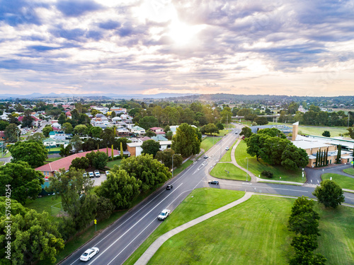 Single ray of light shining down over town of singleton on summer evening