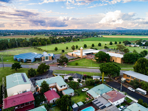 Houses and road with council buildings, public library and playing fields with farmland in distance