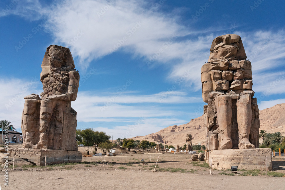 Obraz premium Colossi of Memnon - massive stone statues of the Pharaoh Amenhotep III at the front of the ruined Mortuary Temple, Egypt, Luxor