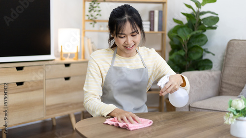 Housewife is cleaning things or Wipe down and dining table in the house the living room, Big cleaning, Housework, Daily routine ,Removes germs and dirt and deep stains, Spray alcohol, Clean up.