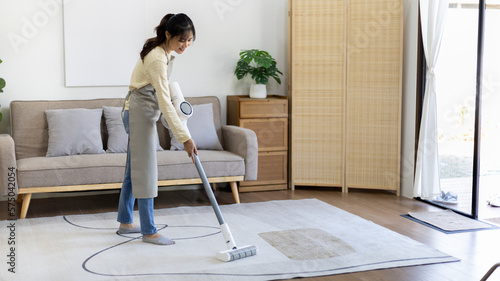 Beautiful woman vacuuming the floor and carpet in her living room, Big cleaning in the house, Removes germs, Housewife cleaning, Keeping her home clean, Domestic hygiene.