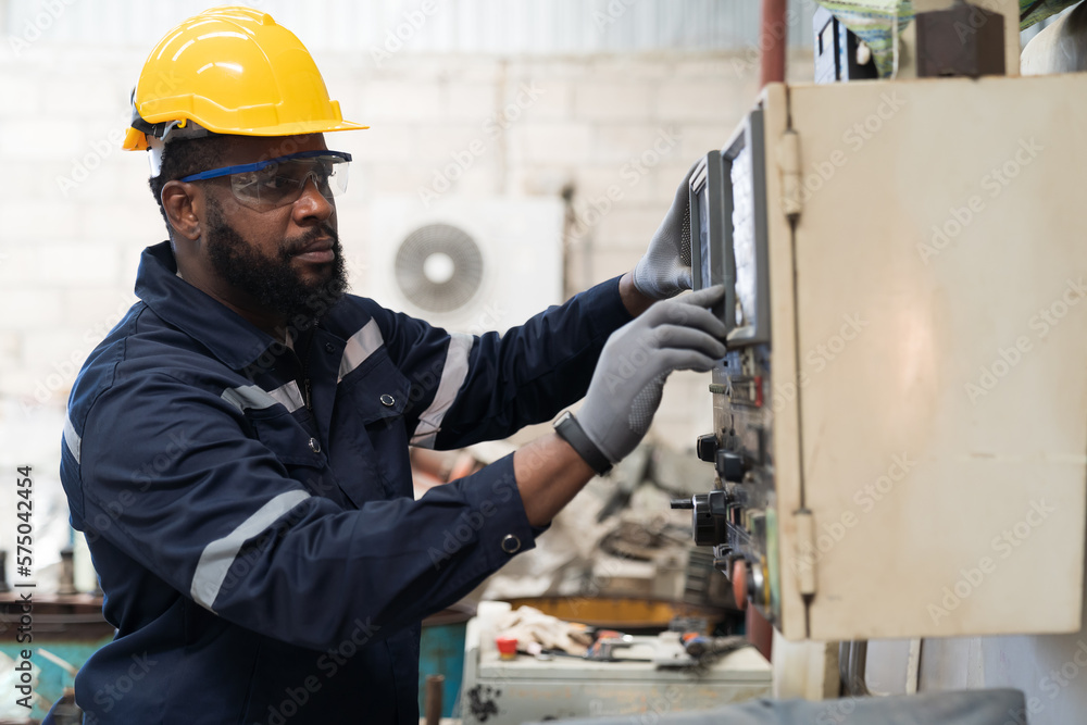 Factory male worker at work in the industry factory, work with CNC machine. Factory engineer male worker maintaining machine in the industrial factory Factory male worker at work in the industry factory, work with CNC machine. Factory engineer male worker maintaining machine in the industrial factory