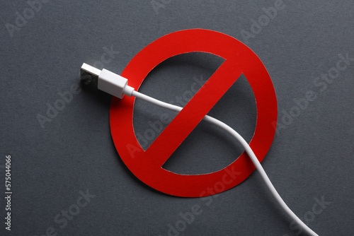 USB cable with prohibition sign on dark background