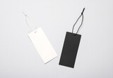 White and black Blank clothing price tags or labels mockup with strings on gray background. Sale, shopping concept. Top view