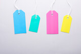Colored Blank clothing price tags or labels mockup with strings on gray background. Sale, shopping concept. Top view