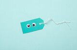 Creative layout, sale, shopping concept. Price tag with eyes on blue background